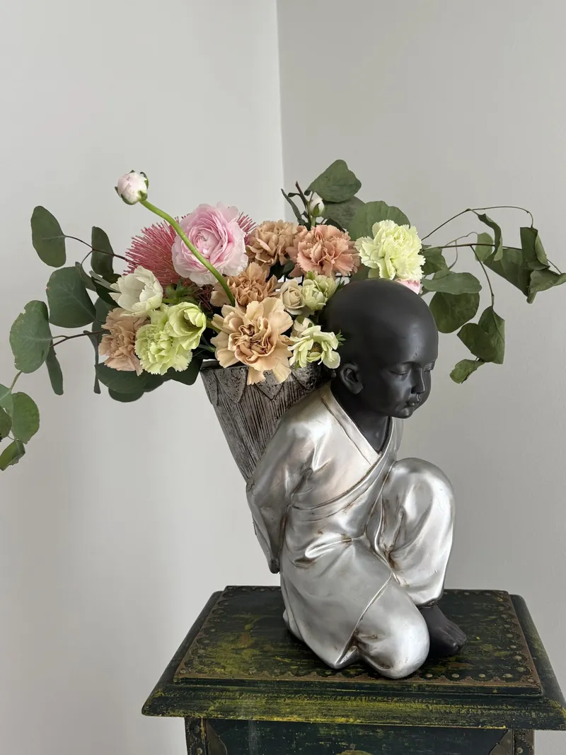 Arreglo floral junto a una escultura