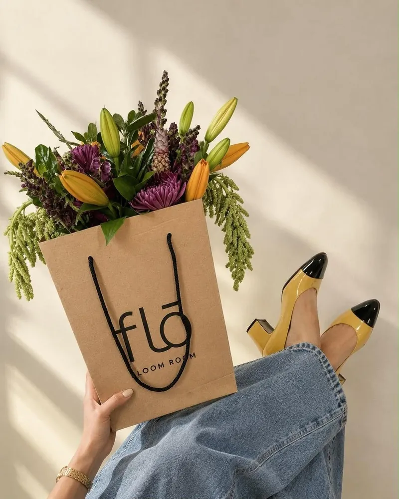 Bolsa de FLŌ con flores en la mano
