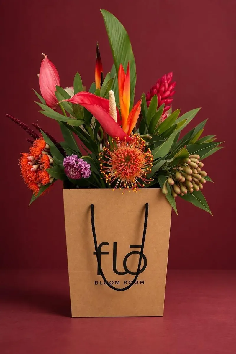 Bolsa con flores tropicales sobre fondo vino